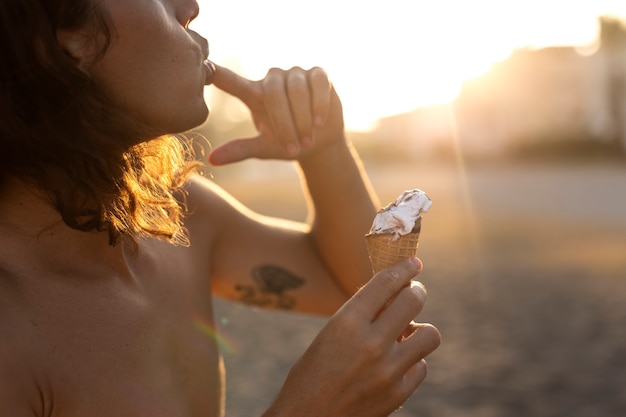 Foto gratuita hombre comiendo helado en la vista lateral junto al mar