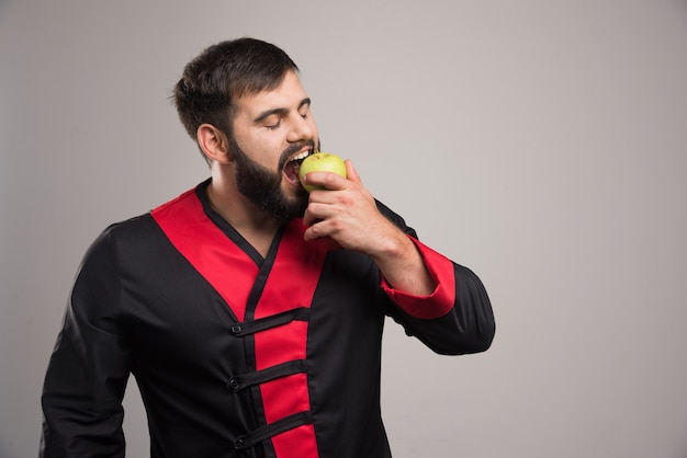 Hombre comiendo una manzana verde fresca.