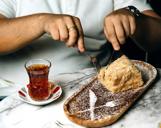 Hombre comiendo un pastel con té