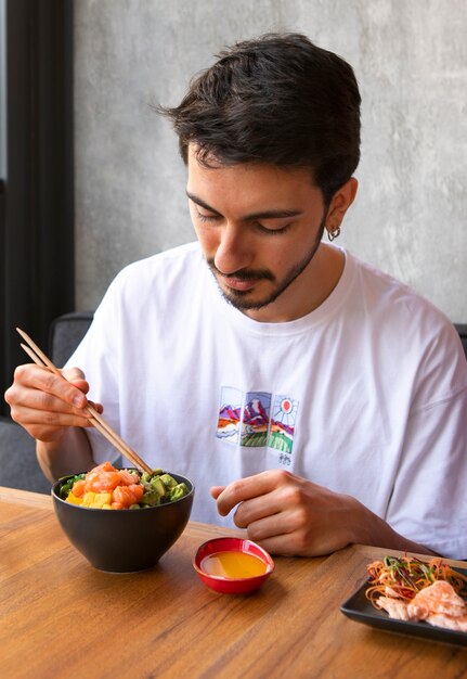 Hombre comiendo plato de salmón en el restaurante