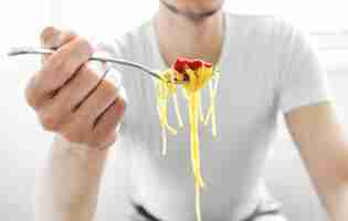 Foto gratuita hombre comiendo sabroso espagueti con salsa de tomate