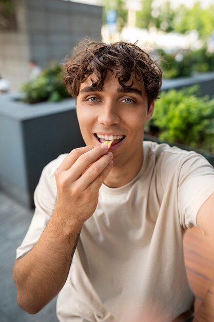 Hombre comiendo sonriente de tiro medio