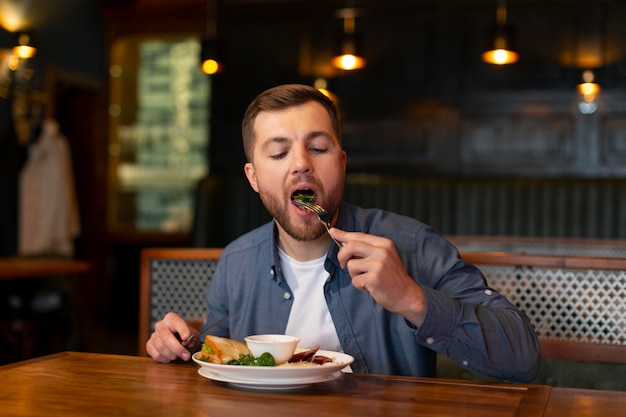 Hombre comiendo de tiro medio