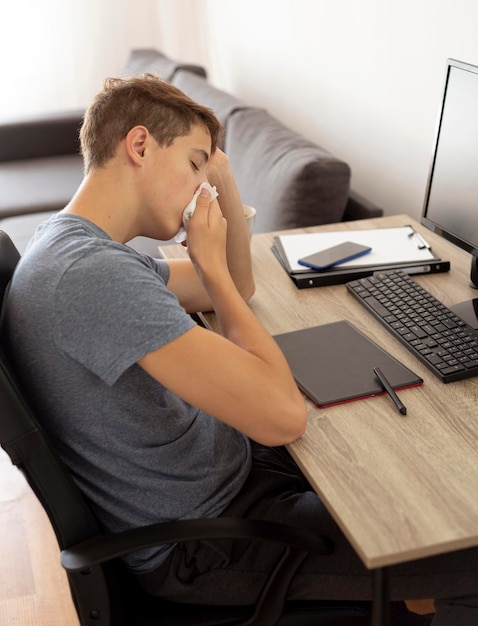 Foto gratuita hombre con computadora en casa en cuarentena trabajando