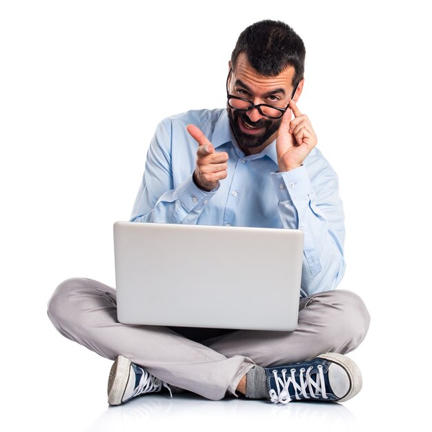 Hombre con la computadora portátil con el pulgar para arriba