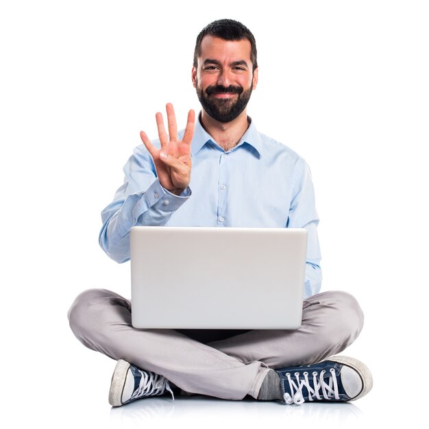 Hombre con la computadora portátil que cuenta cuatro
