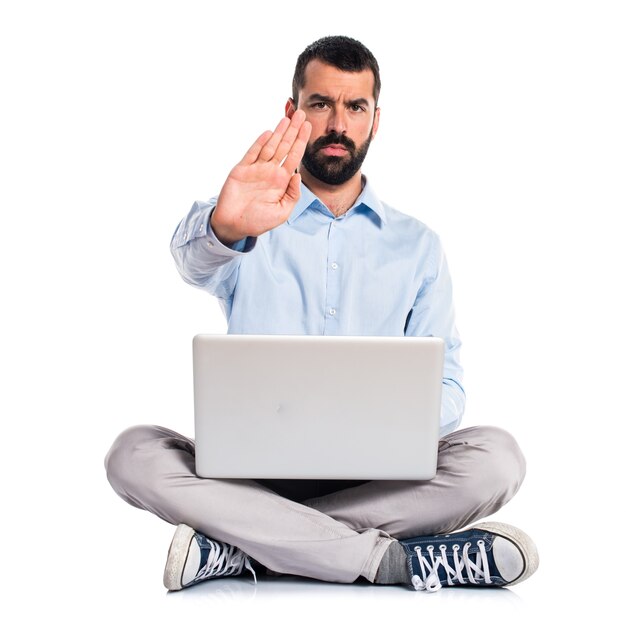 Hombre con la computadora portátil que hace la muestra de la parada