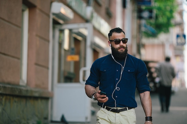 Hombre concentrado caminando mientras escucha música