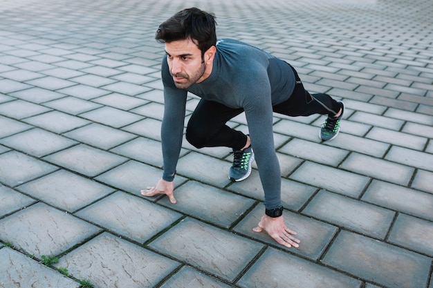 Hombre concentrado haciendo crouch start