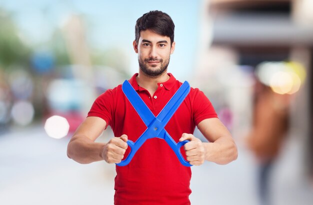 Hombre concentrado jugando con tijeras de plástico