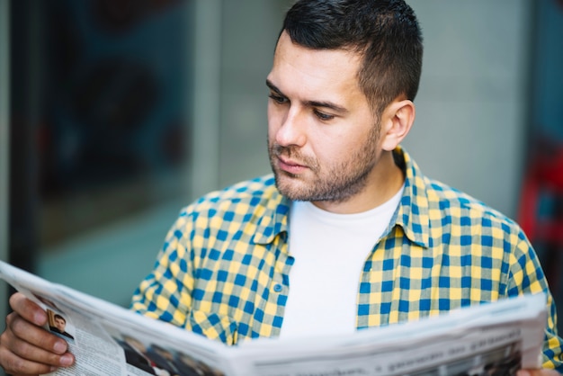 Hombre concentrado leyendo noticias