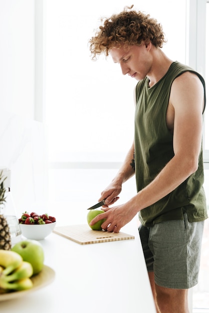 Foto gratuita hombre concentrado de pie en la cocina y cocinar