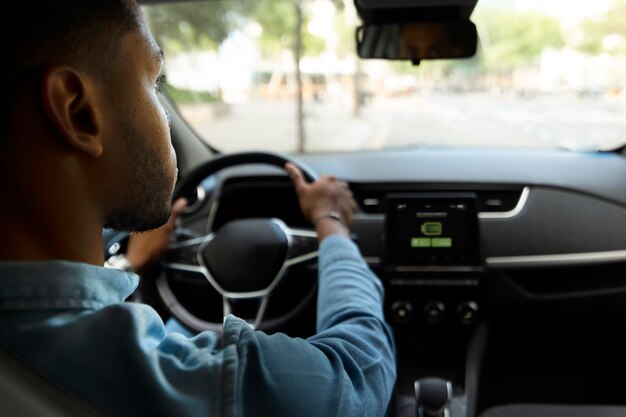 Hombre conduciendo coche eléctrico vista trasera