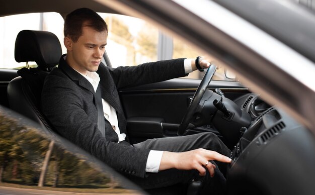 Hombre conduciendo su elegante coche para servicios de taxi