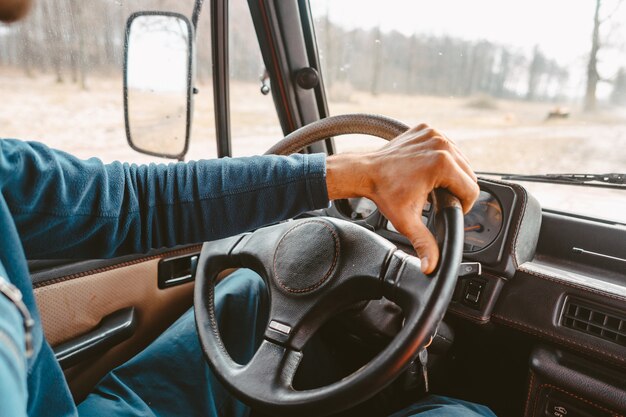 Hombre conduciendo suv coche por camino forestal