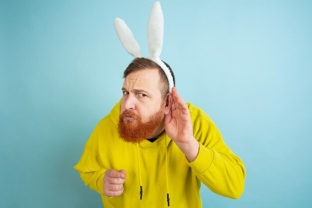 Hombre de conejito de Pascua con emociones brillantes sobre fondo azul de estudio
