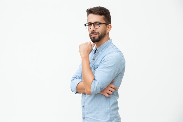 Hombre confiado con la mano en la barbilla mirando a la cámara