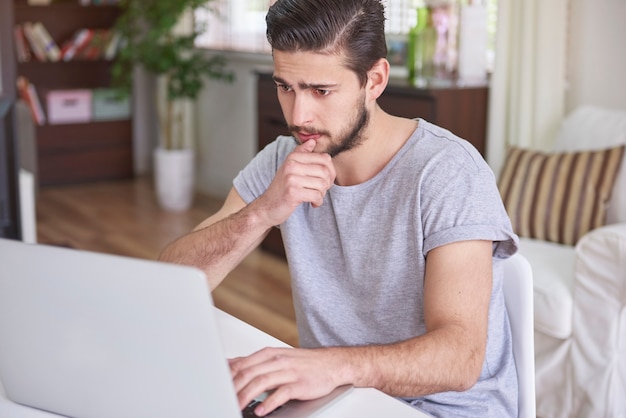 Hombre confundido sentado frente a su computadora