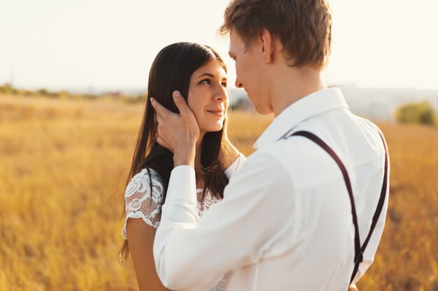 Hombre conmovedor, suave cabello de mujer, sonriendo mientras la mira