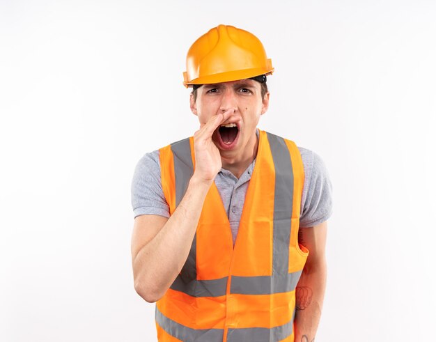 Hombre constructor joven enojado en uniforme llamando a alguien