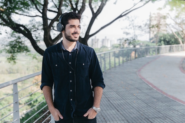 Hombre contenido disfrutando de la música en auriculares