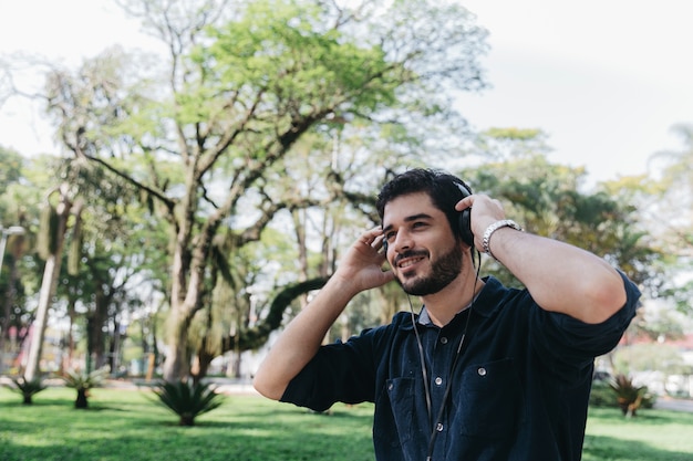 Hombre contenido disfrutando de la música con auriculares