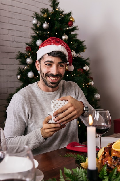 Foto gratuita hombre contento con regalo en cena de navidad