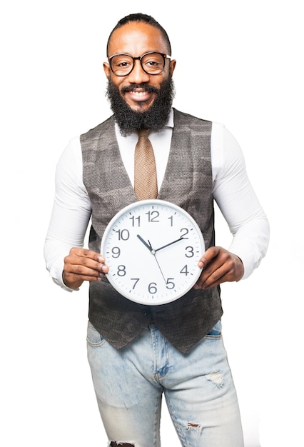 Hombre con corbata sonriendo y sujetando un reloj