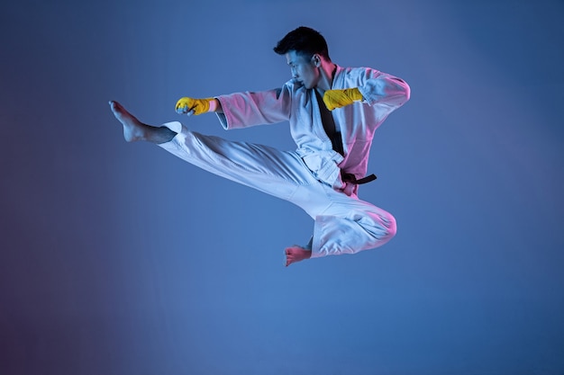 Hombre coreano confiado en kimono practicando artes marciales de combate mano a mano