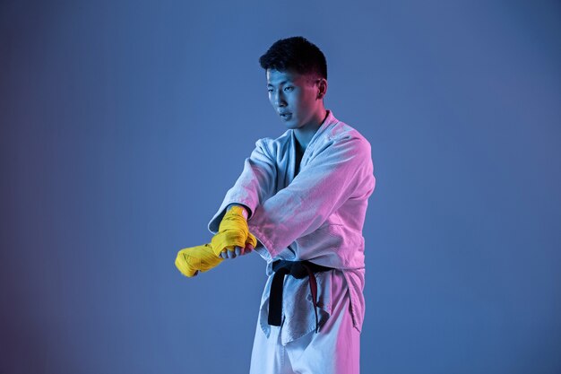 Hombre coreano confiado en kimono practicando combate cuerpo a cuerpo, artes marciales.