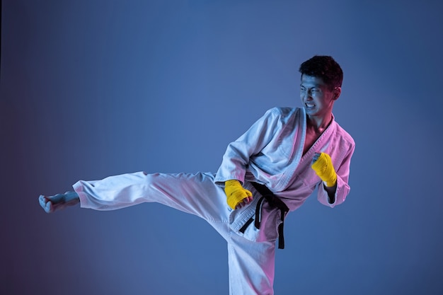 Hombre coreano confiado en kimono practicando combate cuerpo a cuerpo, artes marciales.