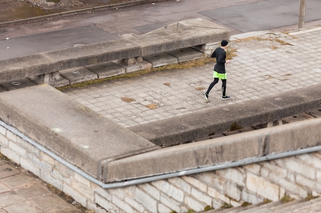 Hombre corriendo en ciudad lluviosa