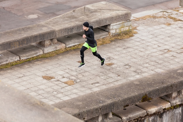 Hombre corriendo en ciudad lluviosa