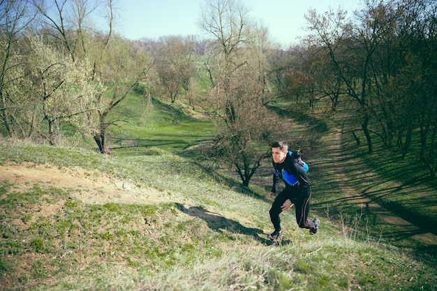 Hombre corriendo en un parque o bosque contra árboles