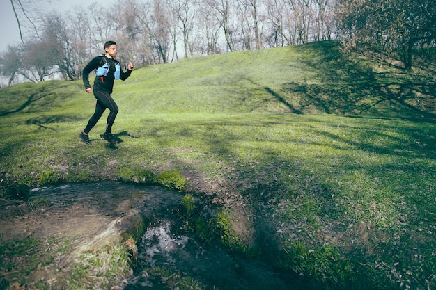 Hombre corriendo en un parque o bosque contra el espacio de árboles