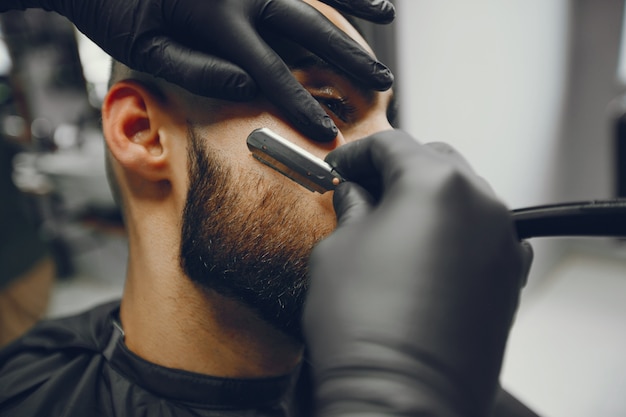 El hombre se corta la barba en la barbería.