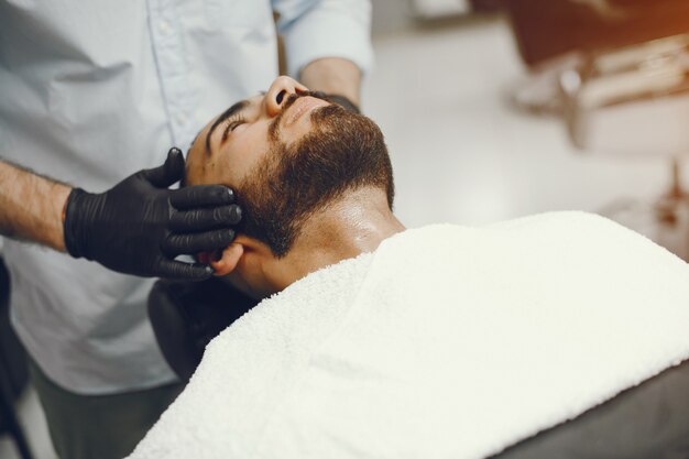 El hombre se corta la barba en la barbería.