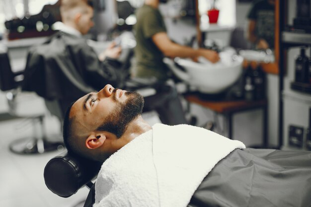 El hombre se corta la barba en la barbería.