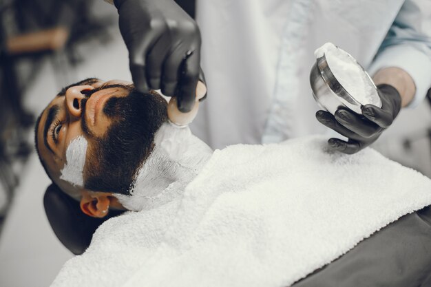 El hombre se corta la barba en la barbería.