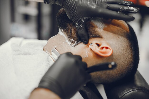 El hombre se corta la barba en la barbería.