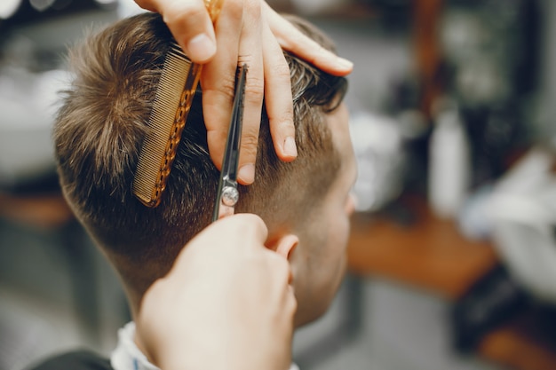 Un hombre corta el pelo en una barbería.