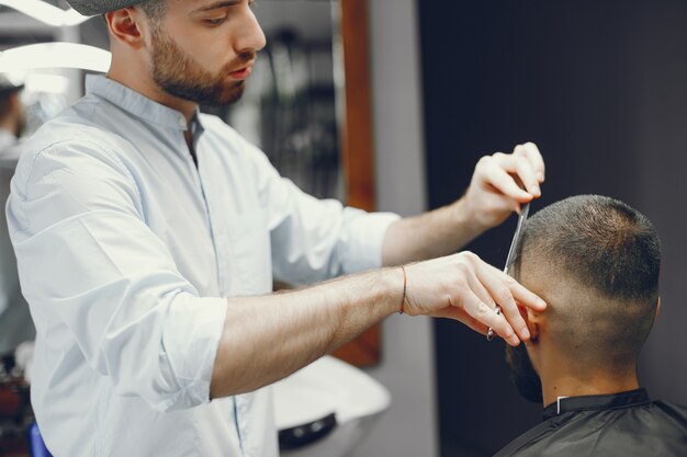 Un hombre corta el pelo en una barbería.