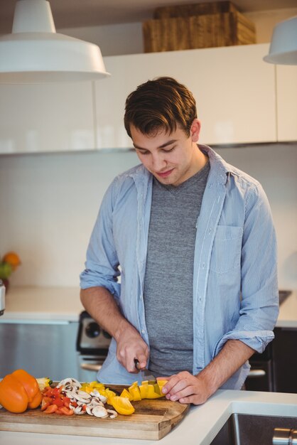 Hombre cortando verduras en la cocina