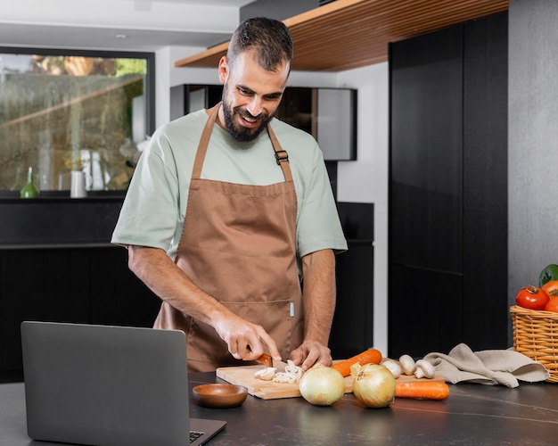 Foto gratuita hombre cortando verduras tiro medio