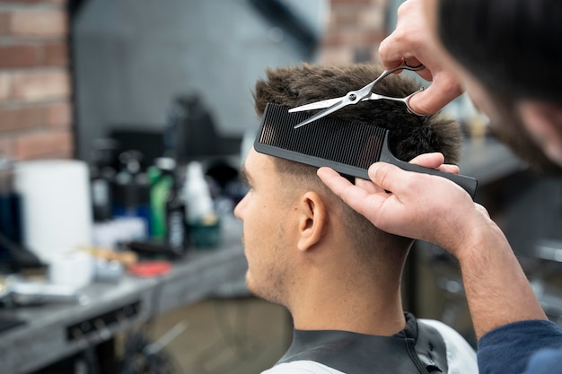 Foto gratuita hombre cortándose el pelo de cerca