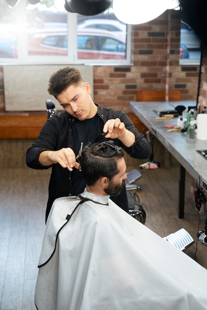 Hombre cortándose el pelo en el salón de tiro medio