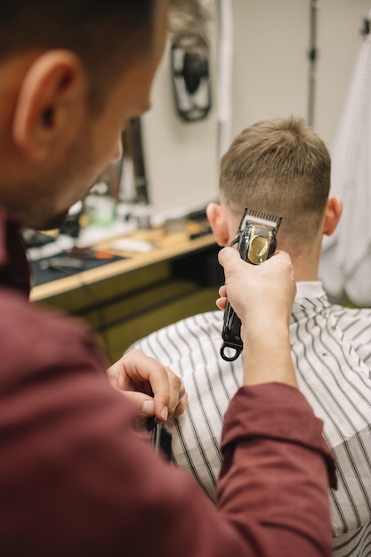 Foto gratuita hombre cortarse el pelo en una barbería