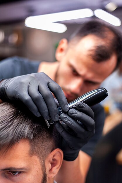 Hombre cortarse el pelo con estilista borrosa