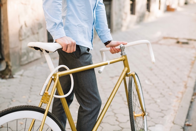 Hombre de la cosecha con la bicicleta que se coloca en el pavimento