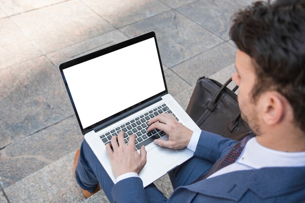 Hombre de cosecha usando la computadora portátil en las escaleras